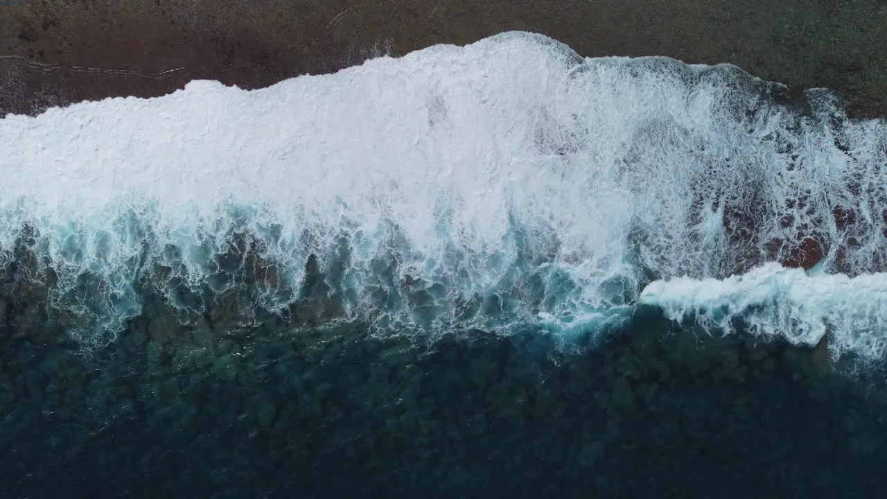 Aerial  Bird’s eye view of stormy waves crashing on coastline of Loyalty islands New Caledonia