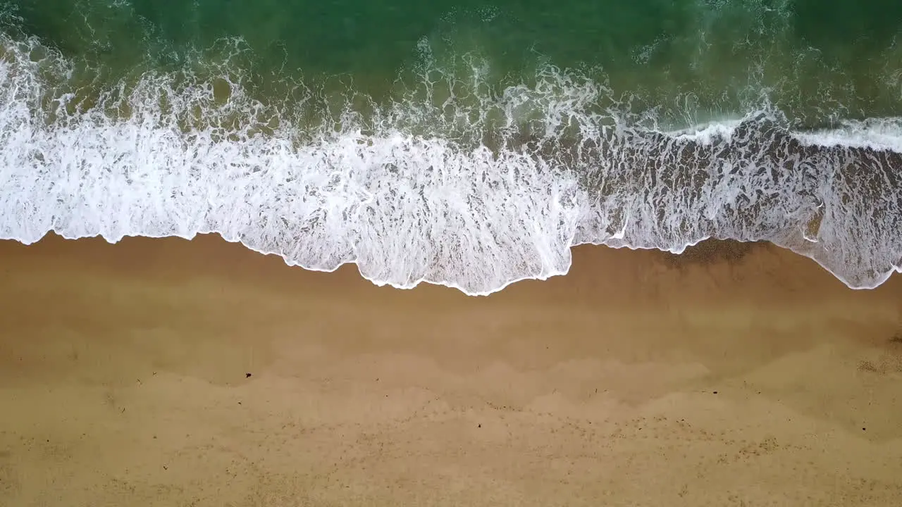 Top down aerial view of waves breaking on the coast calming perspective drone