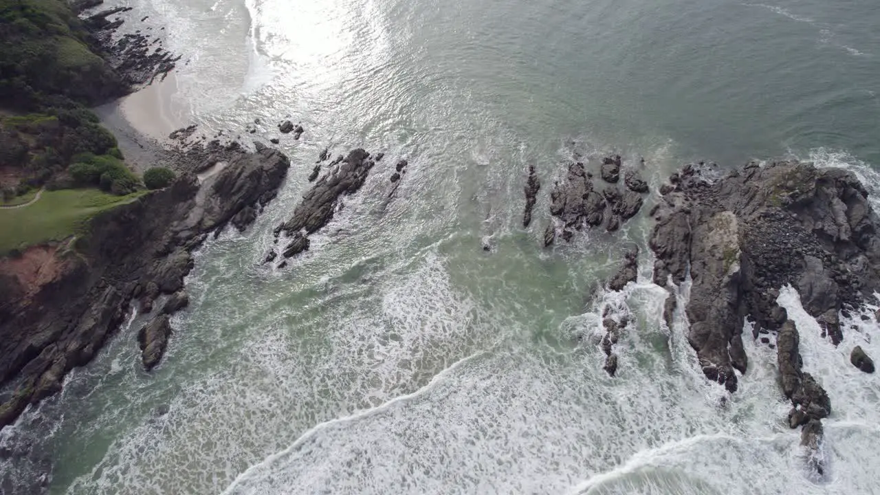 Waves With Foam Splashing On Rocky Shore At Broken Head New South Wales Australia aerial top down