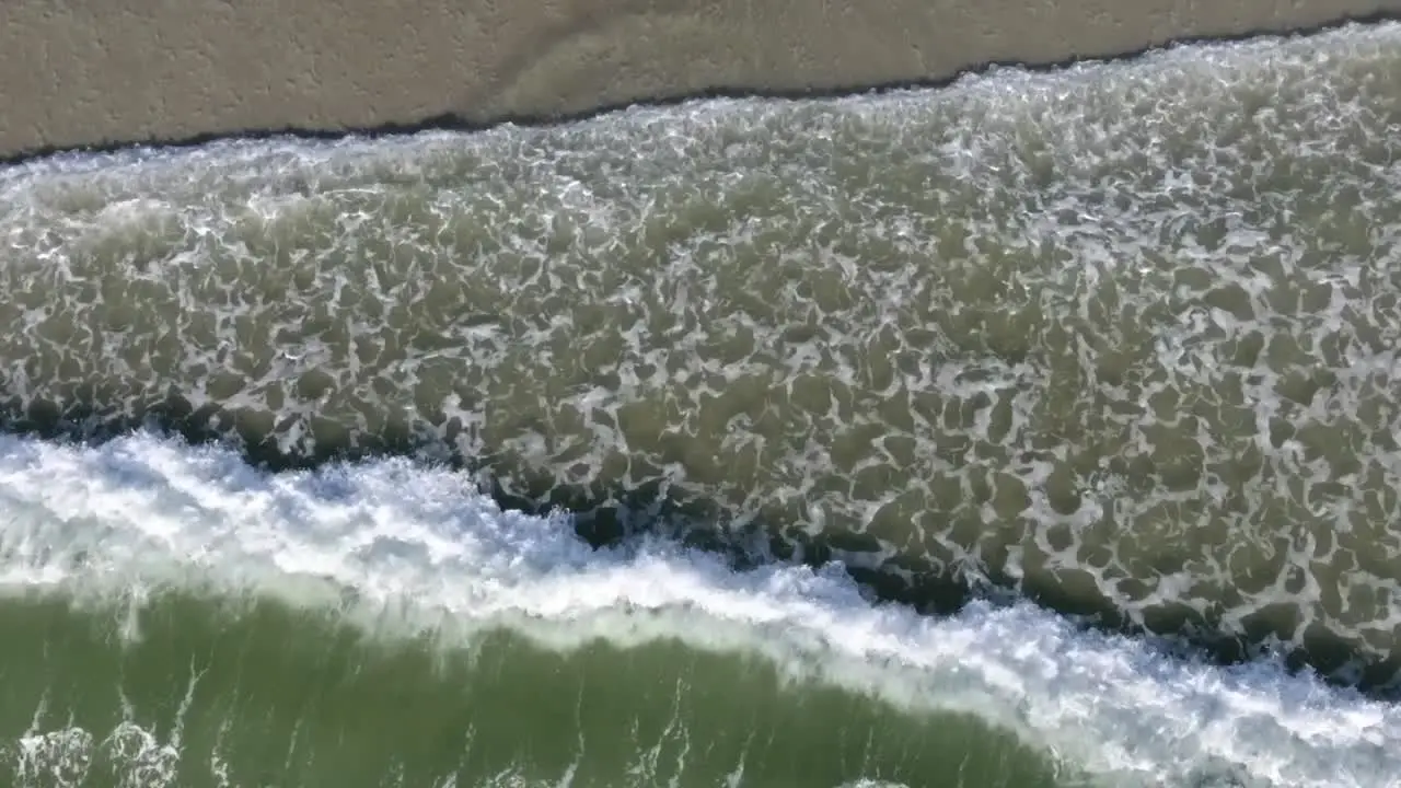 Aerial view of waves straight down on sea shore