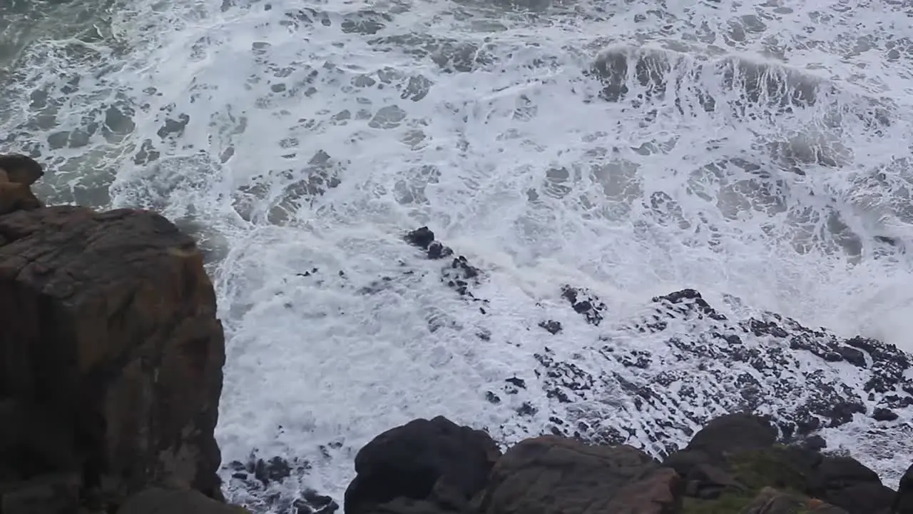 Waves swell and crash against the rocks high angle