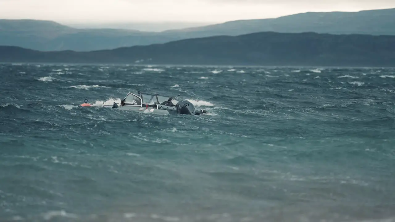 A small motorboat tied to a buoy is sinking battling strong wind and powerful waves in the fjord