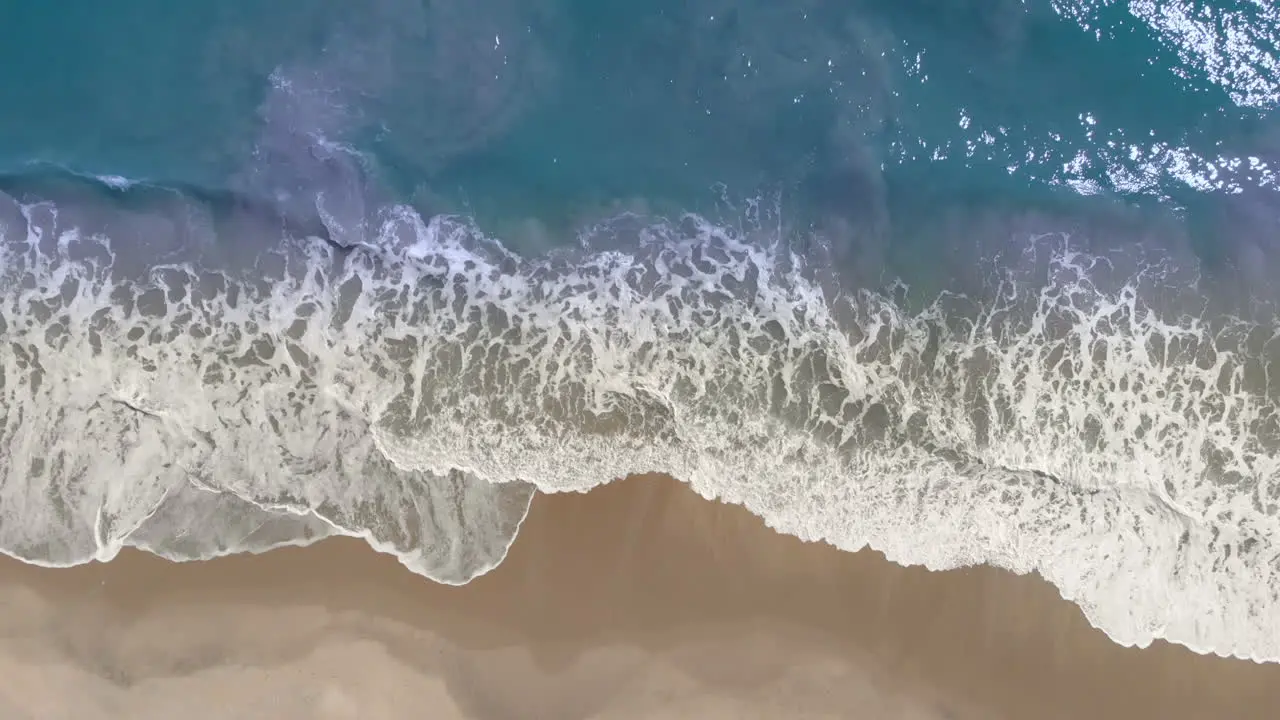 Aerial View Of Looping Ocean Wave Reaching the Coastline on tropical golden beach