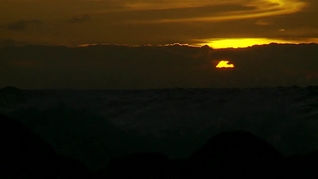 The sunset behind waves as they crest and break in slow motion at sunset 6