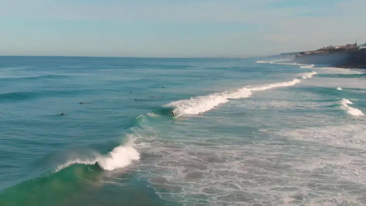 This super slow motion video shows a group of surfers in the ocean one catching and riding a wave-1