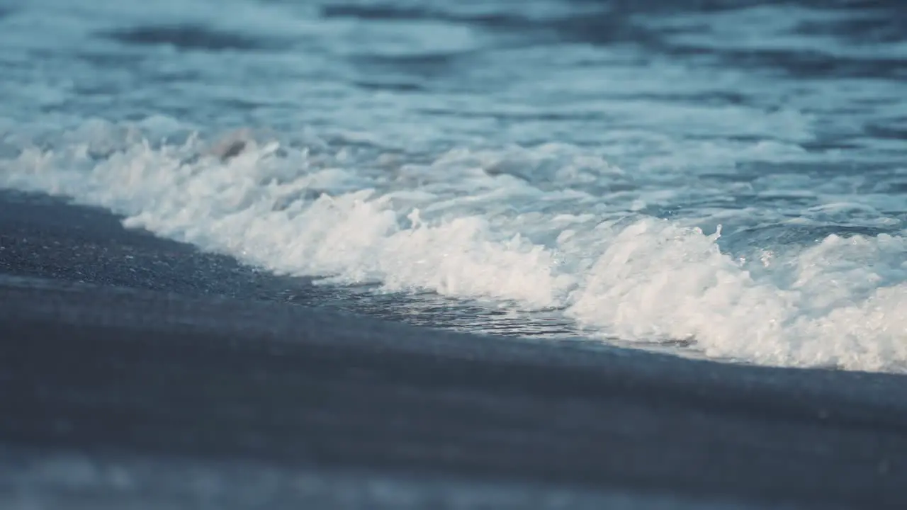 Waves break around the sandy beach in Ersfjord