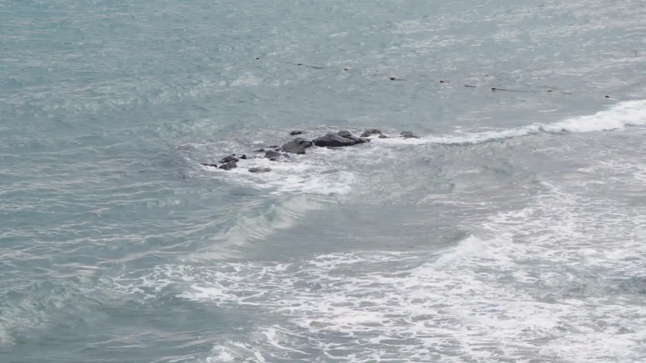 Rocks in the middle of the waves at the sea 4K