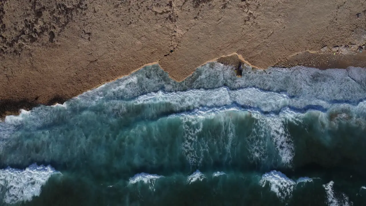 Waves hitting beach top down drone view of relaxing ocean coast background