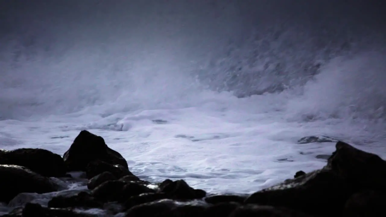 Water level view of waves crashing and rolling into a rocky shore in slow motion