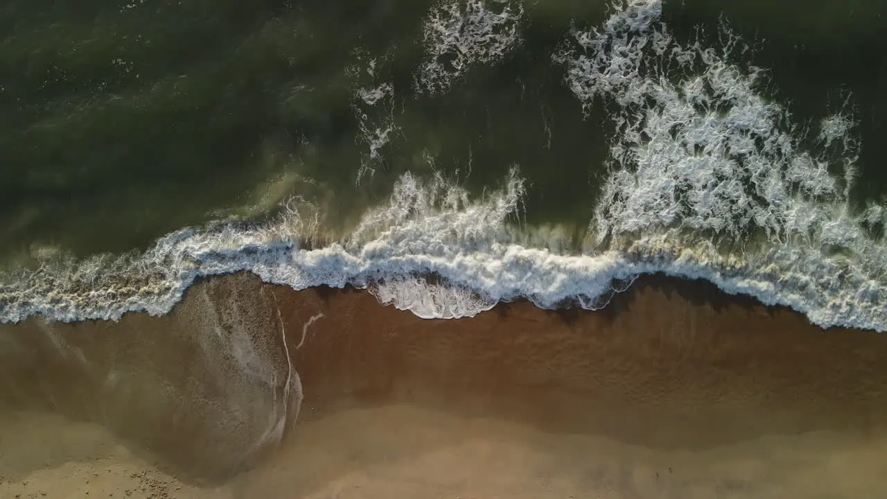 Ocean waves crashing on sandy shore