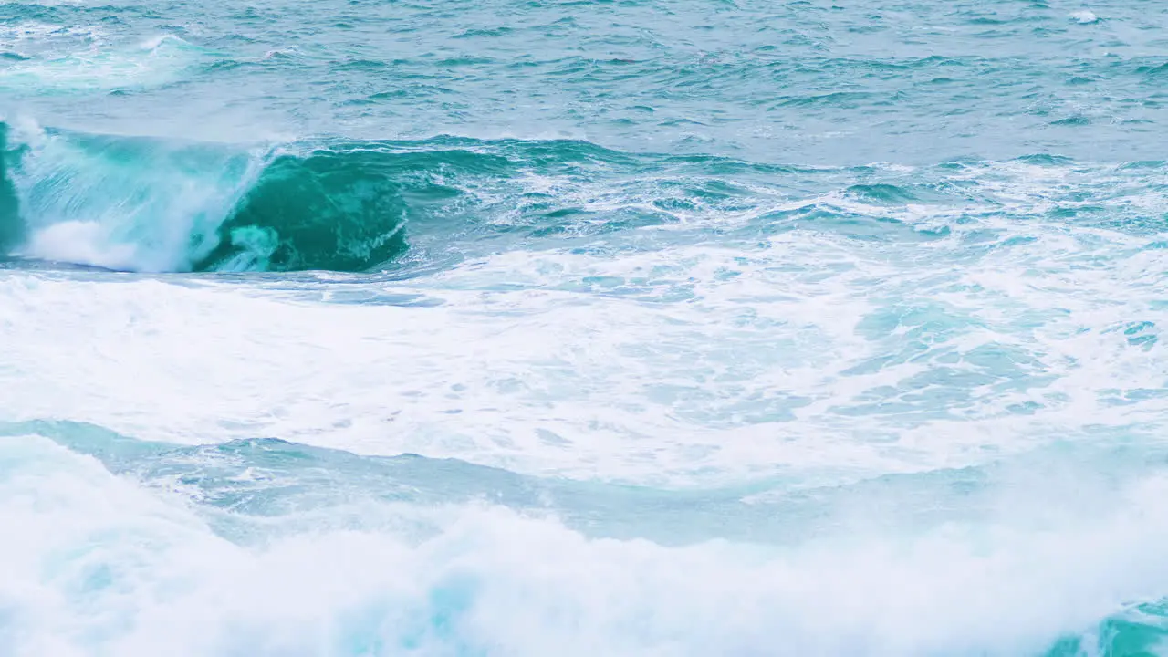 Big waves crushing near shore creating mist and foam restless sea on stormy weather