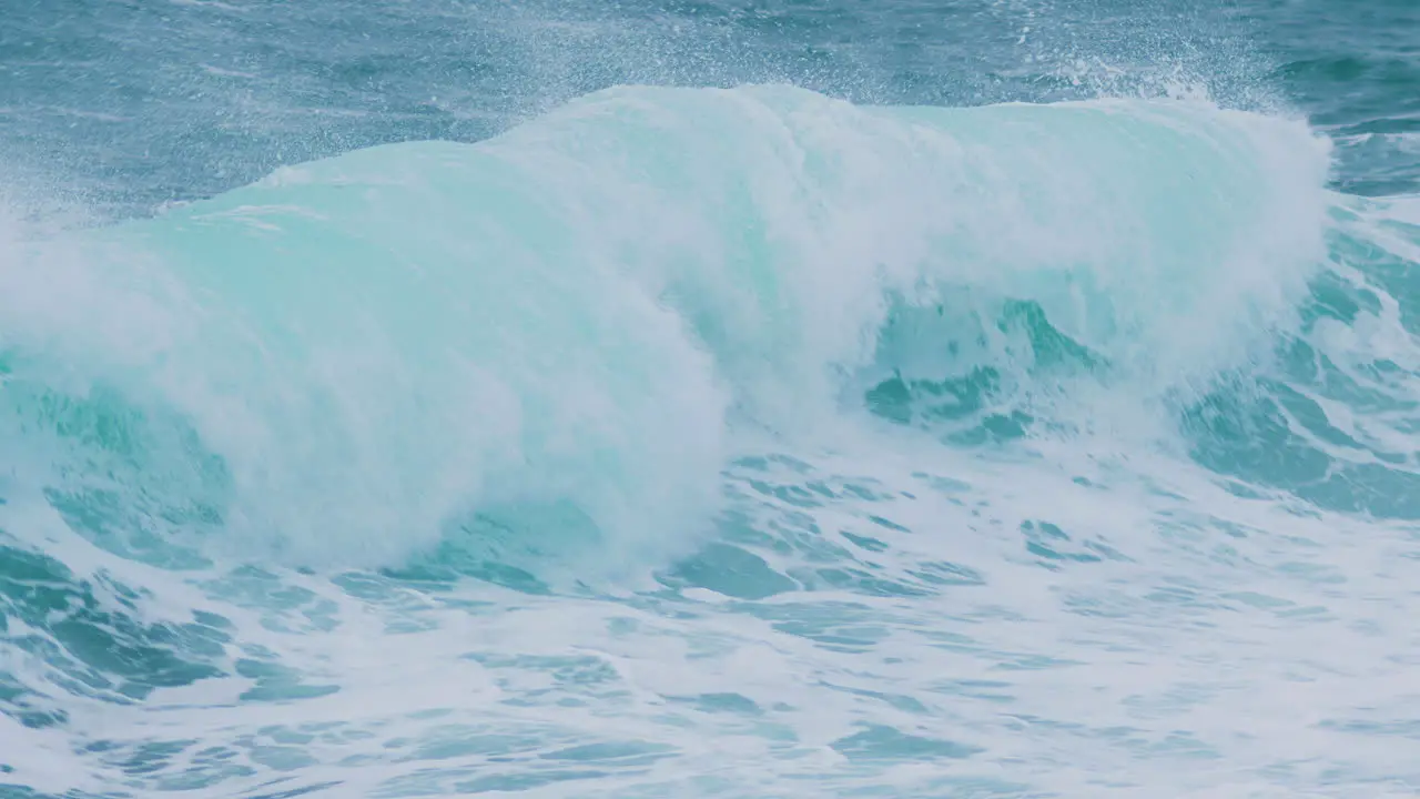 Sea waves creating crest touching rocky shore