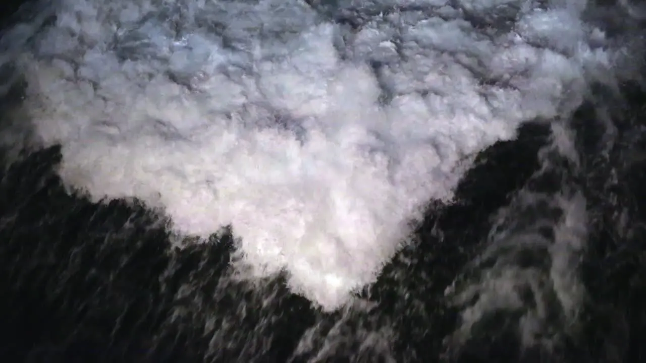 Large churning prop wash wake chasing the stern of a cruise ship under way at night