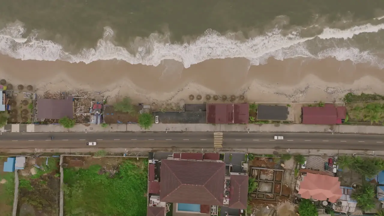 Top down aerial footage of a road and beach and ocean waves just outside of Freetown Sierra Leone