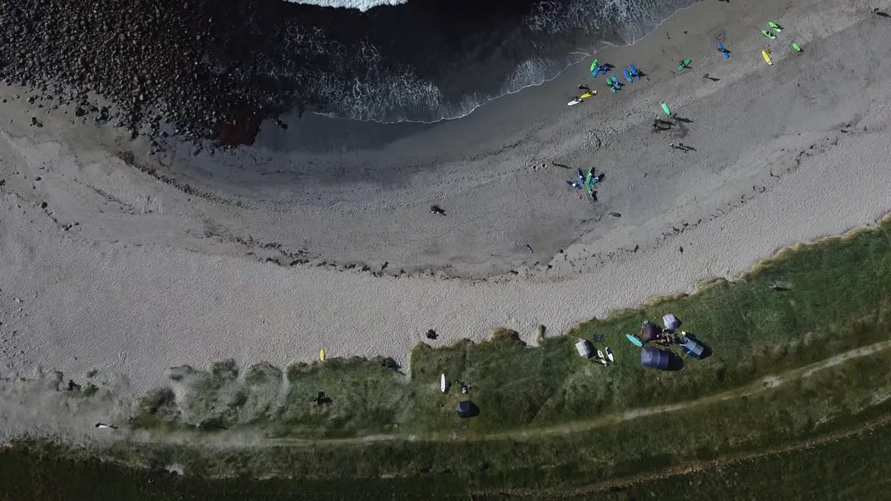 vacationers enjoying gray sandy beach and Turquoise water in summer aerial view