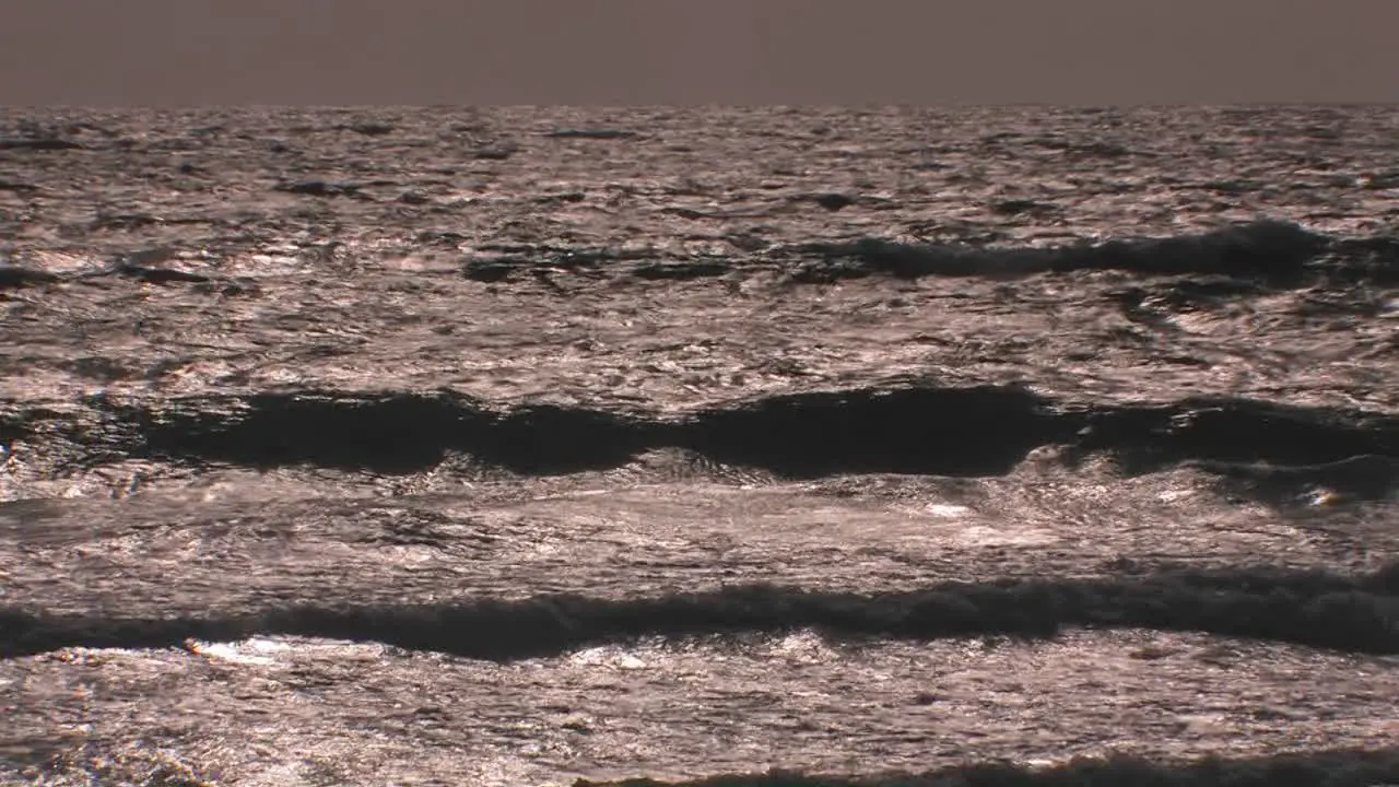 Choppy waves continuously break and roll onto shore 1