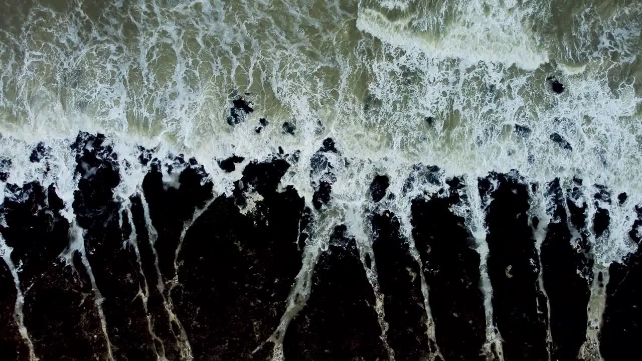 Top Down Aerial View Of Waves Crashing Along Kingsgate Coastline