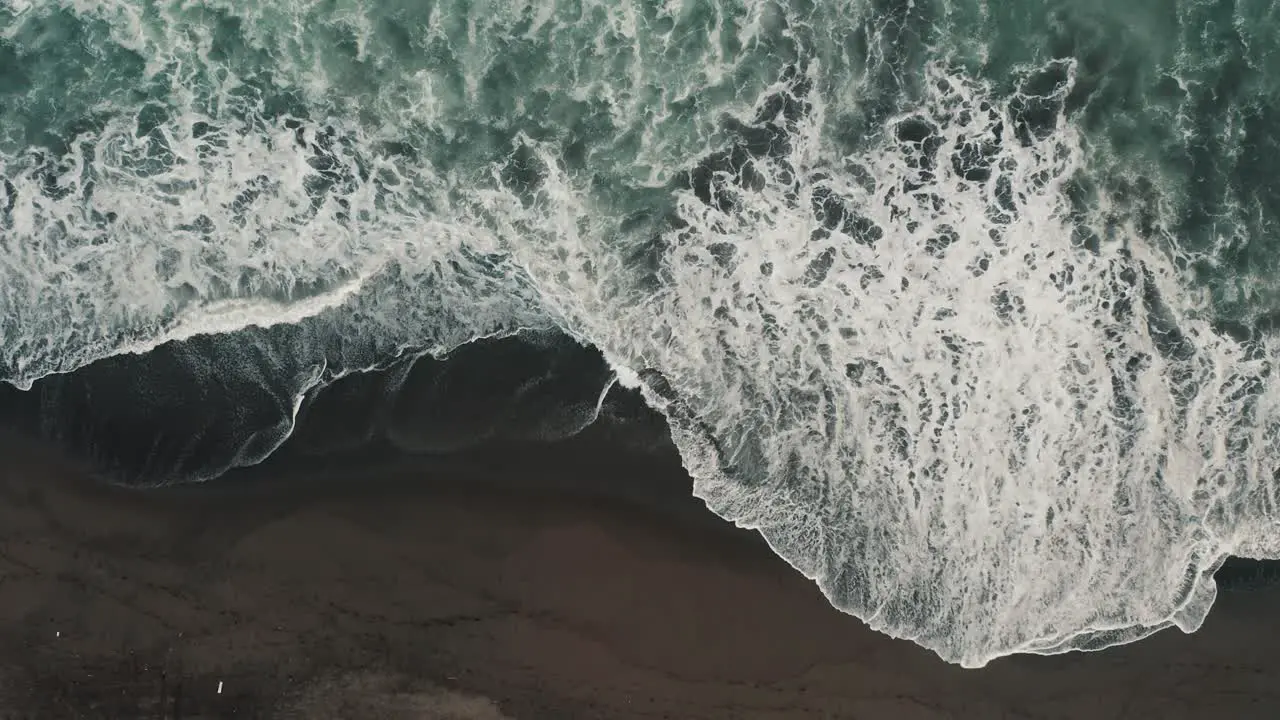 Ocean Waves With Foam Splashing On The Black Sand Beach Of El Paredon In Guatemala aerial top down