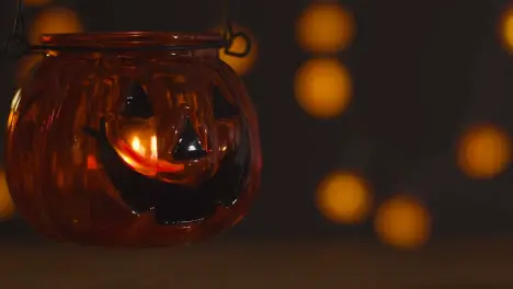 Halloween Pumpkin Jack-O-Lantern With Candle And Lights In Background