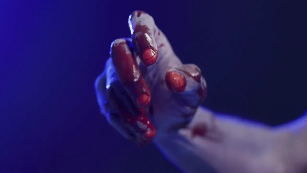 Video of hand covered with blood moving on black background