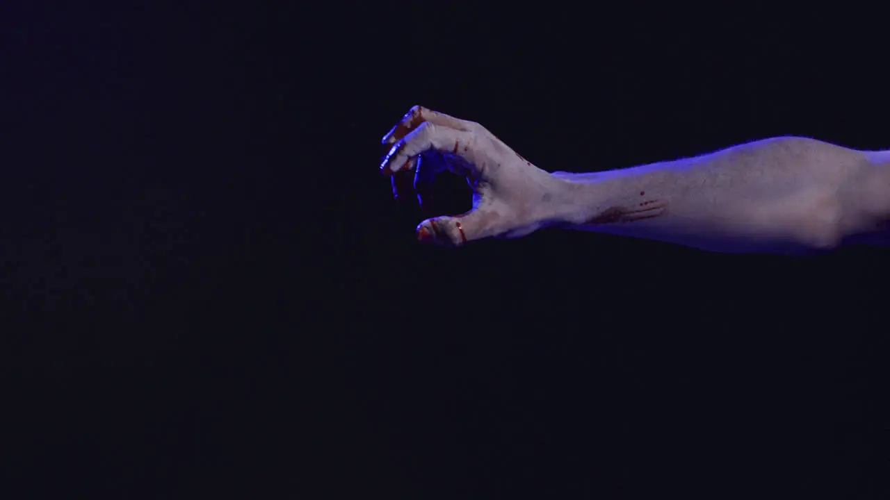 Video of hands covered with blood moving on black background