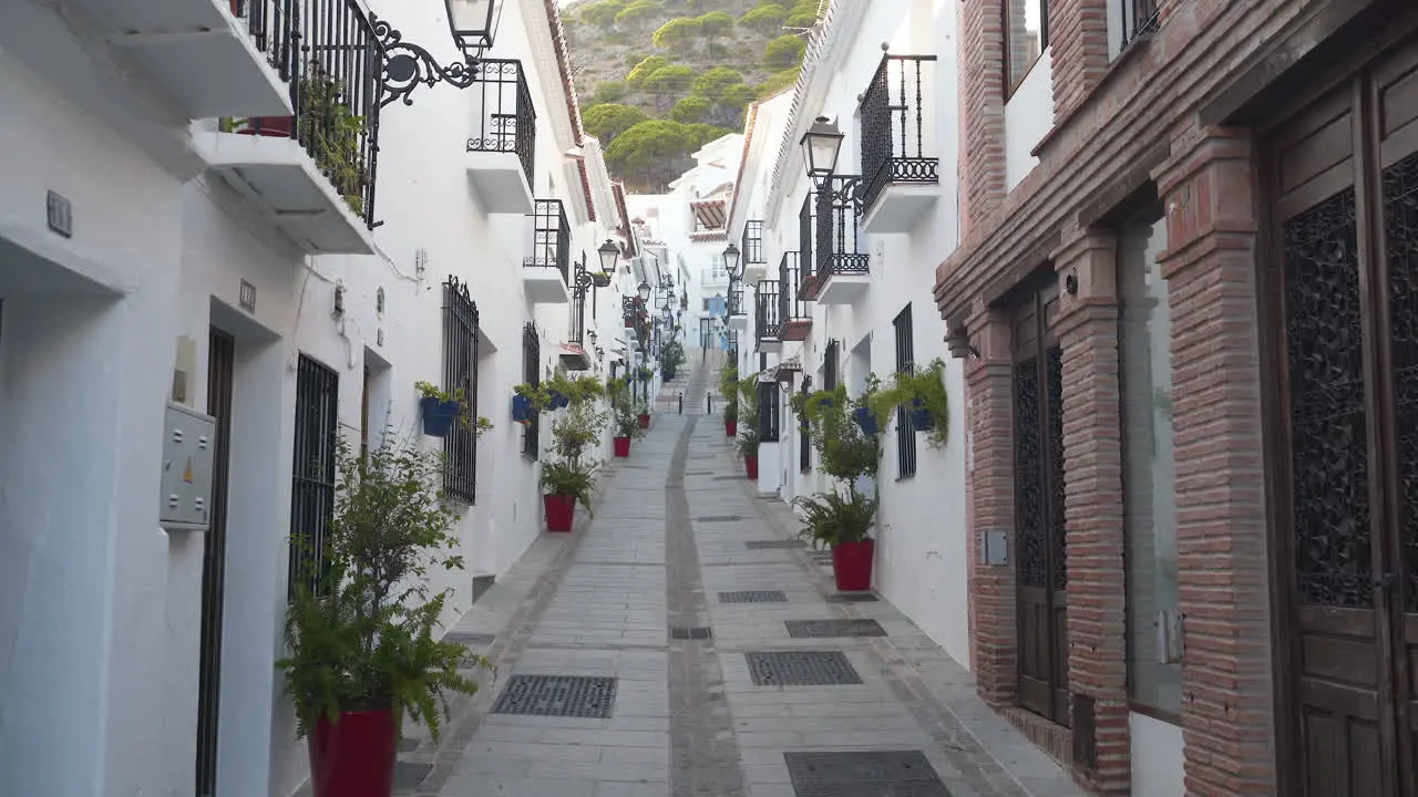 Empty narrow street in spanish town Mijas with white facade houses