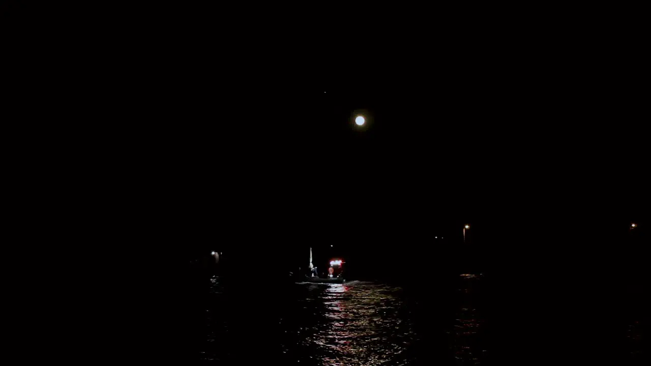 Small lit up boat in a sea at Mussel farmers huts