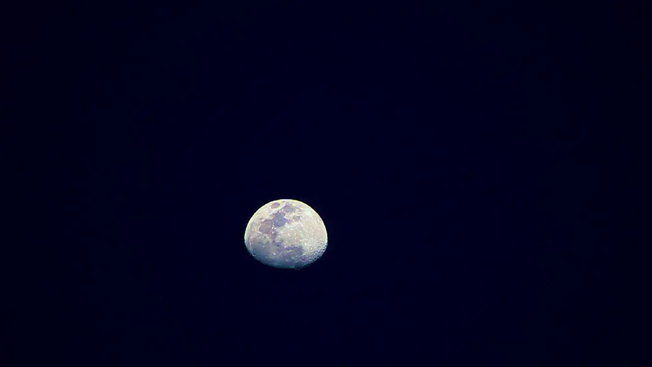 Moon changes colors yellow blue then purple moves from bottom to to of screen time lapse