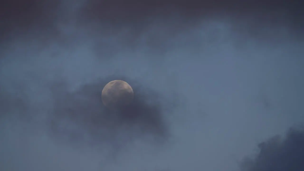 Timelapse Shot of a Full Moon Rising in the Sky Being Obscured by Rolling Dark Clouds