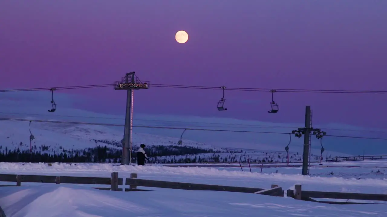 Person riding a ski lift in Idre Fjäll in Sweden during a colorful sunset-1