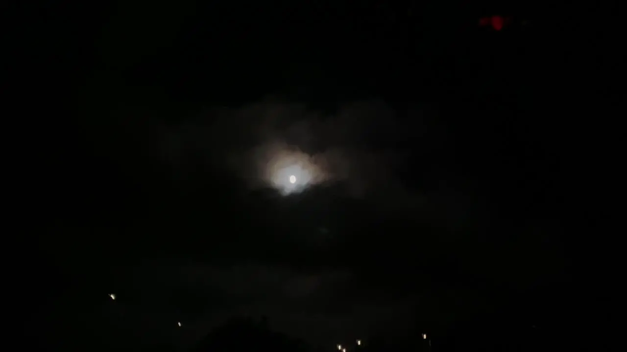 Strong wind drives across the sky thick clouds on the background of the full moon