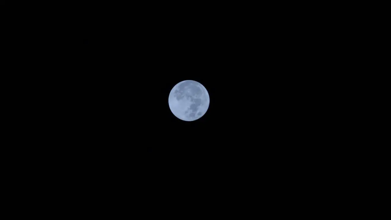 Full moon moving against dark night sky