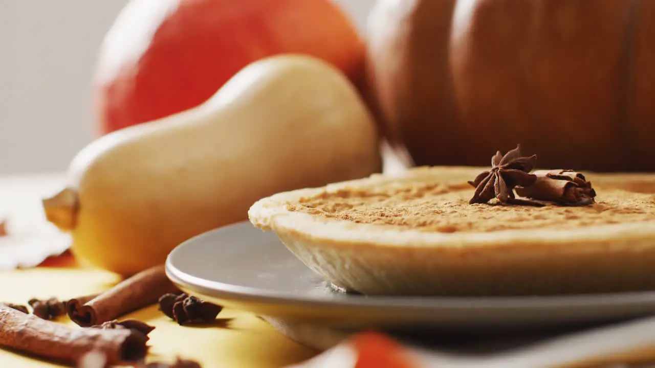 Video of autumn leaves pumpkins spices and pie on grey background