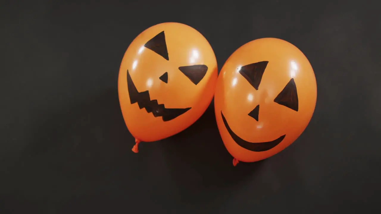 Two scary faces printed halloween balloons floating against grey background