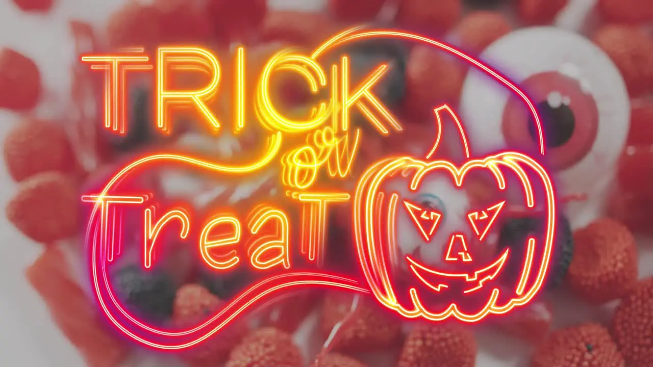 Neon trick or treat text banner with pumpkin icon against scary eye toy and halloween candies