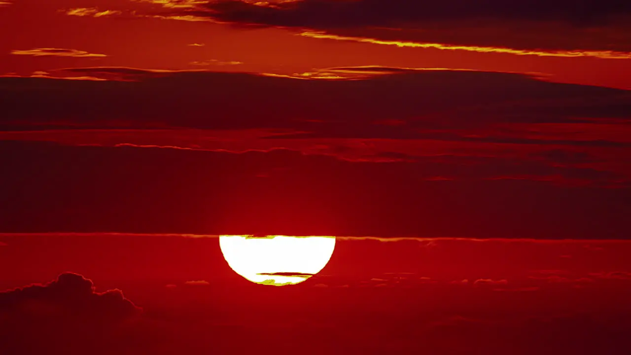 Bright Moon Behind Layers Of Clouds In Red Horizon