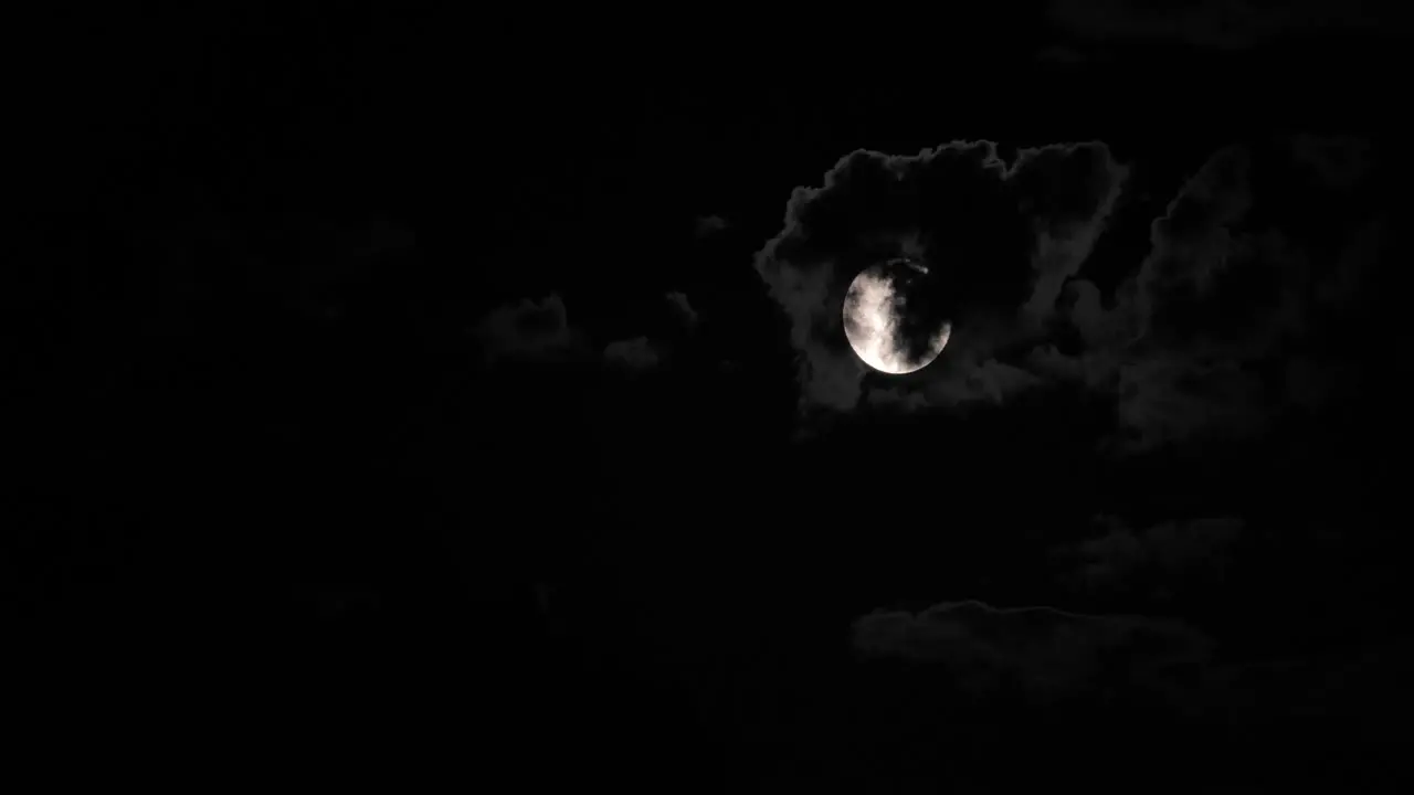 Super moon behind clouds at night