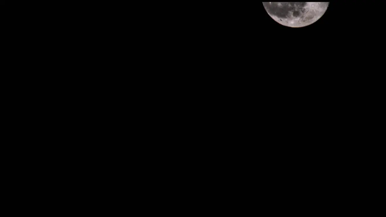 This is a shot of the moon rising from bottom left of the shot and disappearing out of the top right of shot