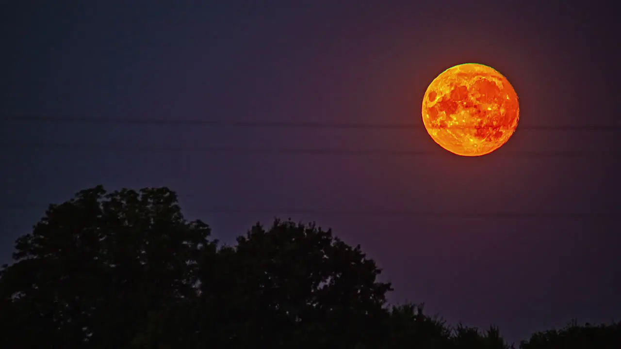 Full glowing lunar moon flowing on night sky with visible craters time lapse