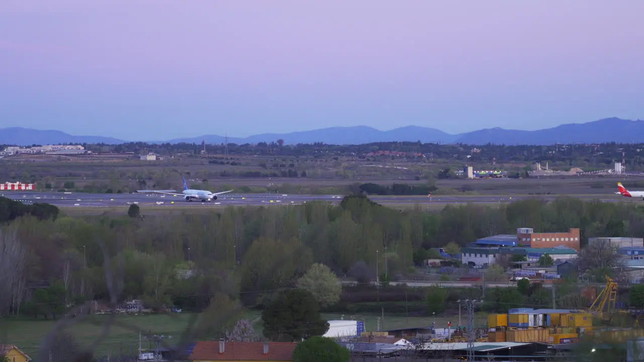 Plane taking off at sunrise with mountains in the background