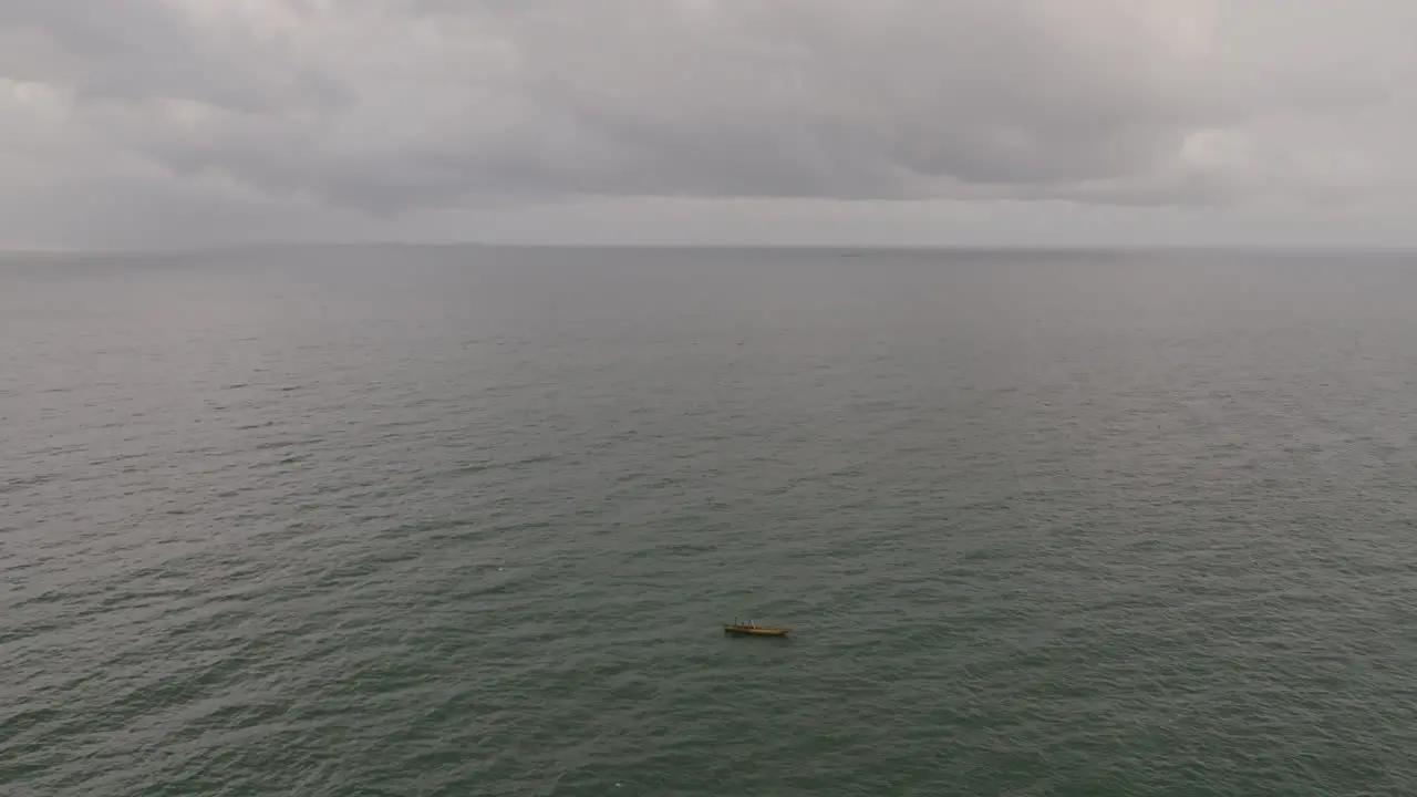 Aerial footage of a single boat on the vast ocean fishing just outside of Freetown Sierra Leone