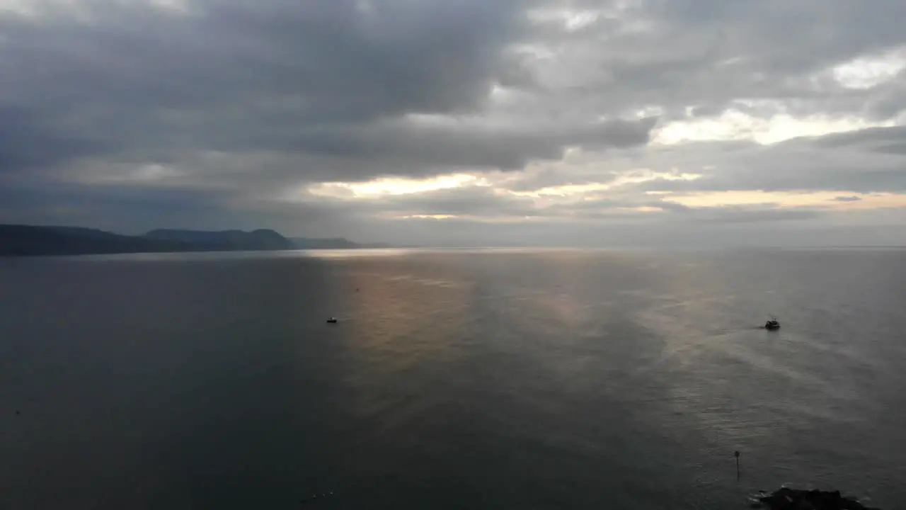 Aerial shot looking over the sea and coastline of the Jurassic coast from Lyme Regis England with a dramatic early morning sunrise