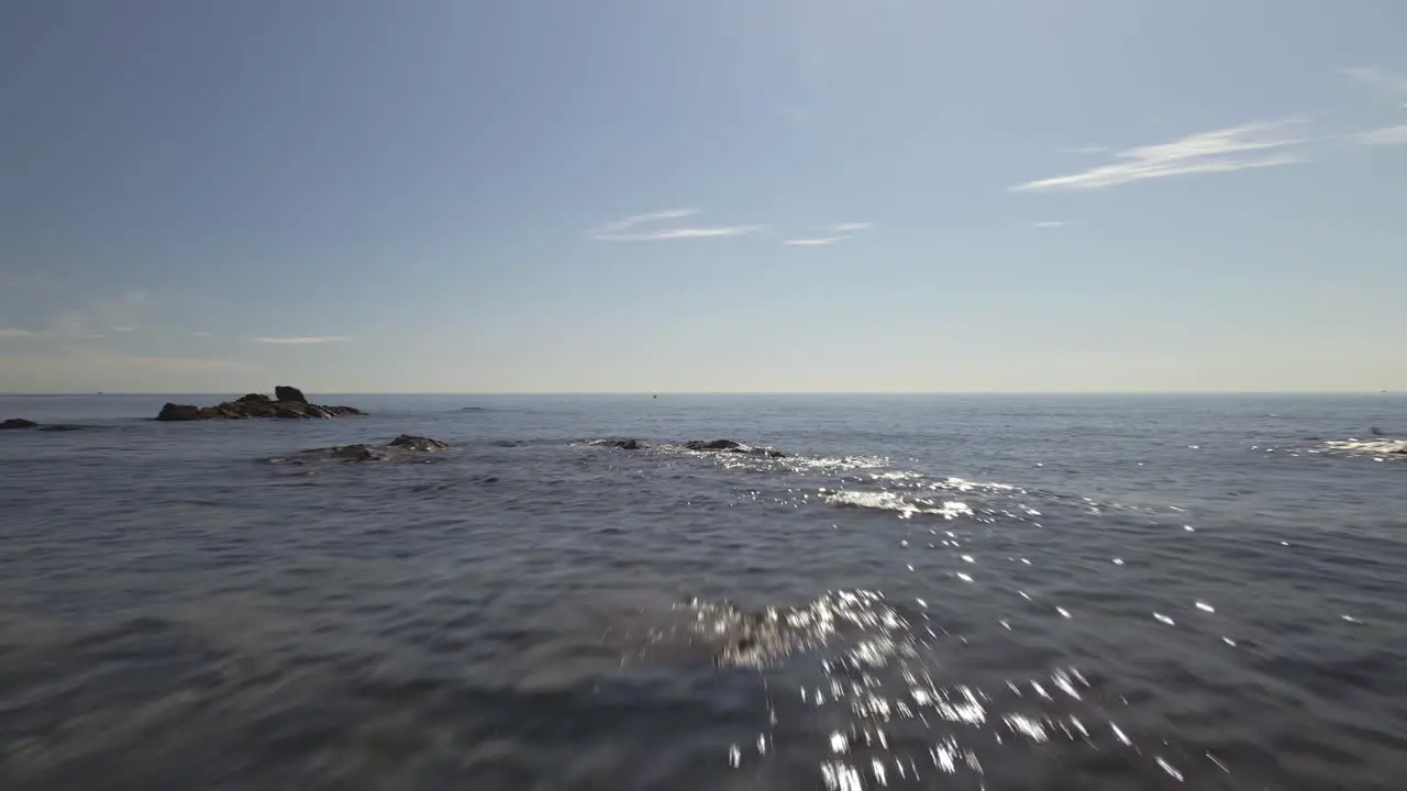 Aerial view of rocky coastline moving forward into the sea