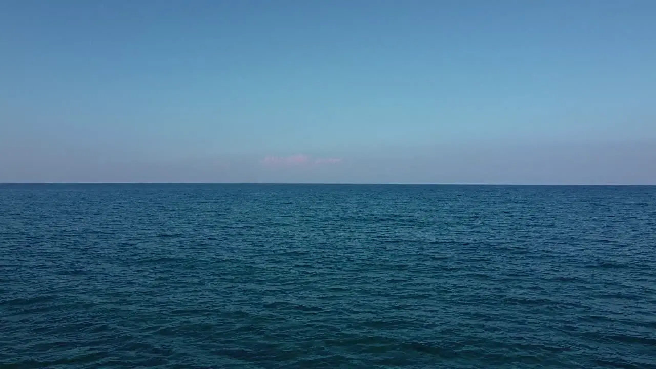 A child sits alone on the edge of a dock