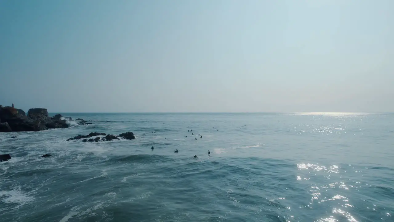 Static shot of a group of surfers waiting for the perfect wave to roll through