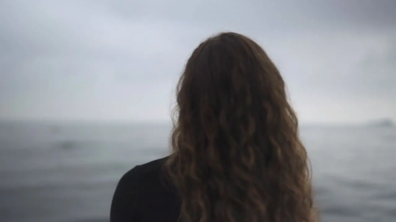 Brunette Girl Move Curly Hair With Ocean In The Background