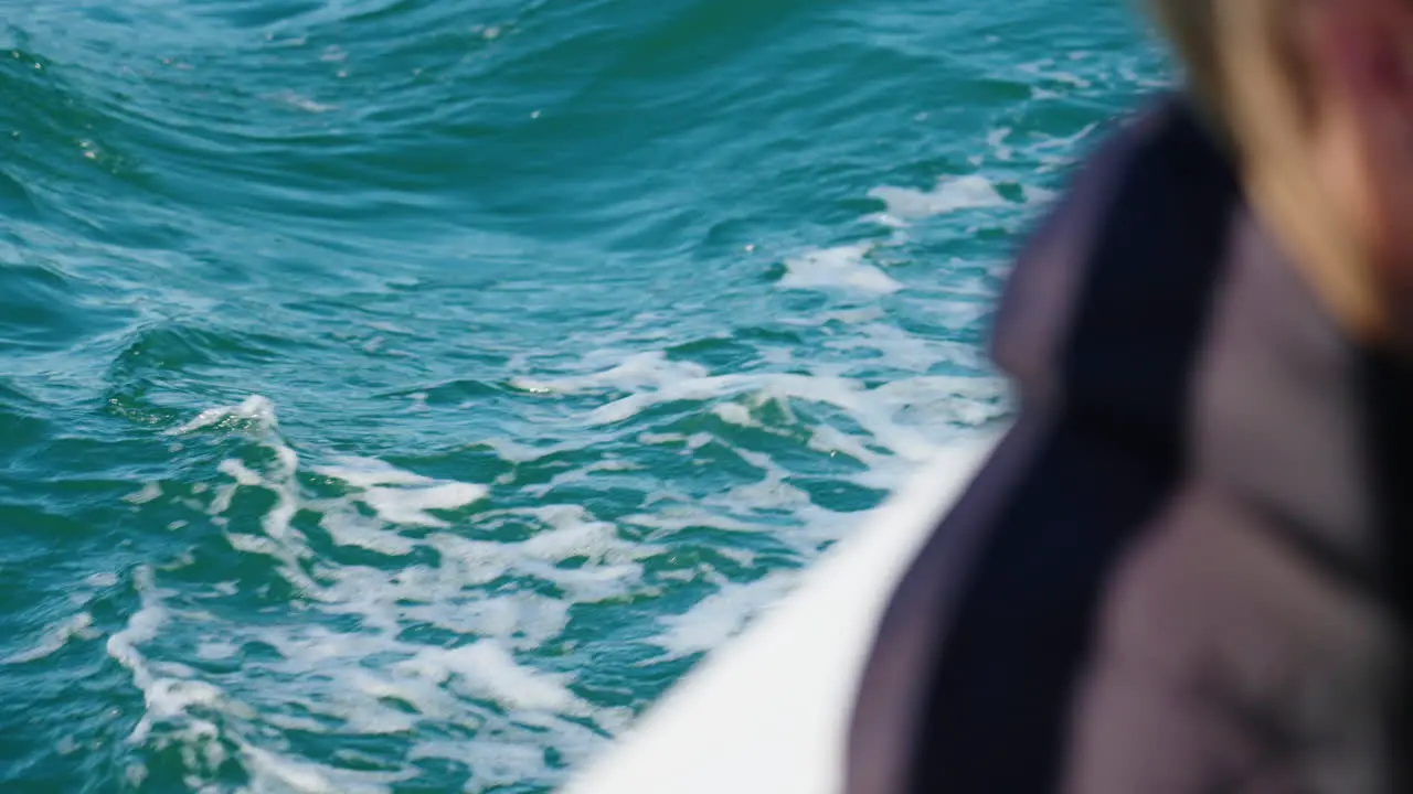 Close Up Of Blue Ocean Wake Beside Boat With Passenger Looking Over Water 4K Australia