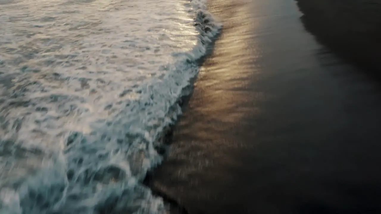 Foamy Waves Splashing On The Black Sand Beach Of El Paredon In Guatemala At Sunset drone shot