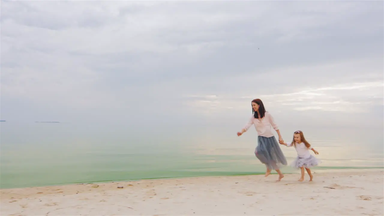 Carefree Mother And Daughter Three Years Running By The Beach