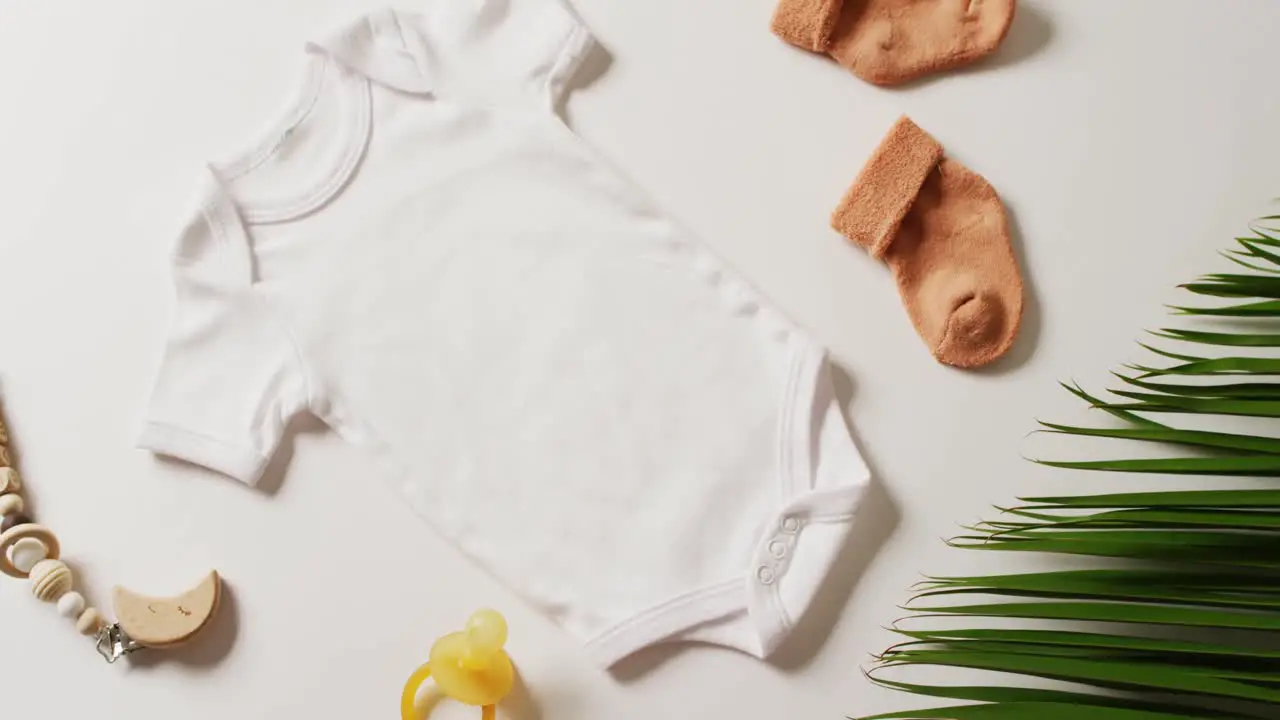 Video of close up of white baby grow socks and dummy on white background